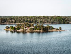 A tranquil island with cottage surrounded by calm water in Stockholm Archipelago.