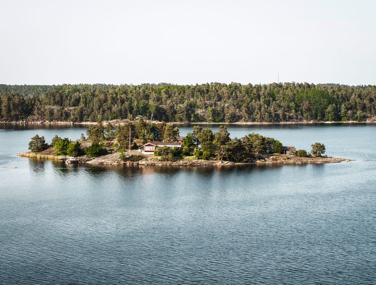 A tranquil island with cottage surrounded by calm water in Stockholm Archipelago.